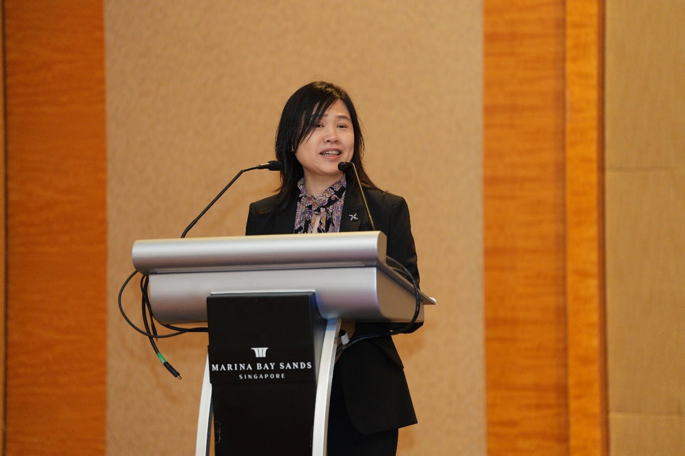 Woman speaking at a stage podium.