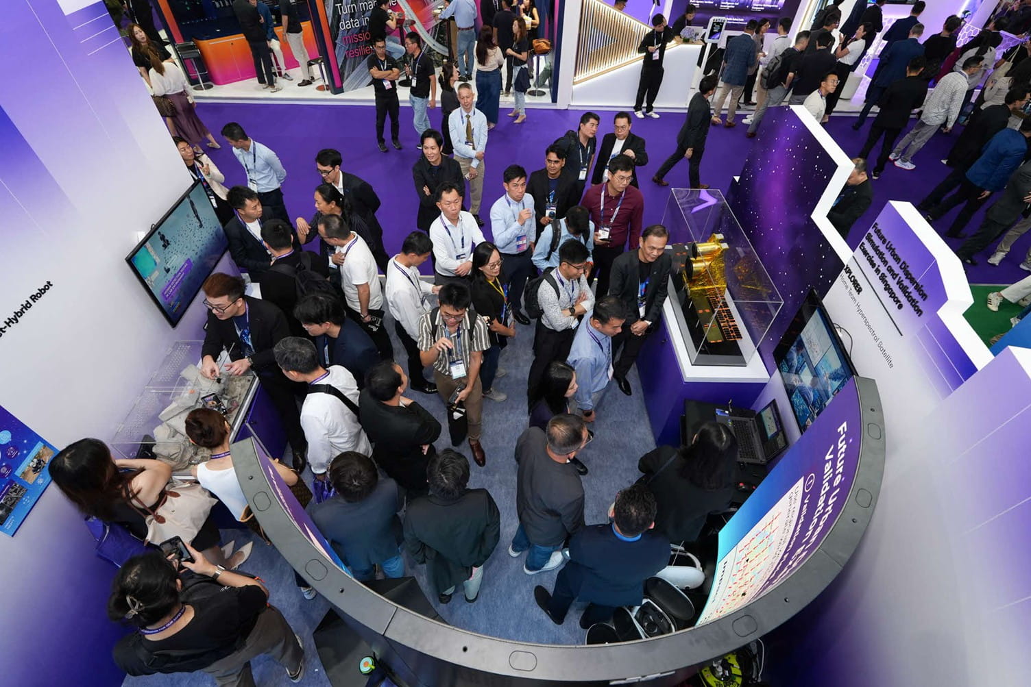Large group of people at a tech exhibit.