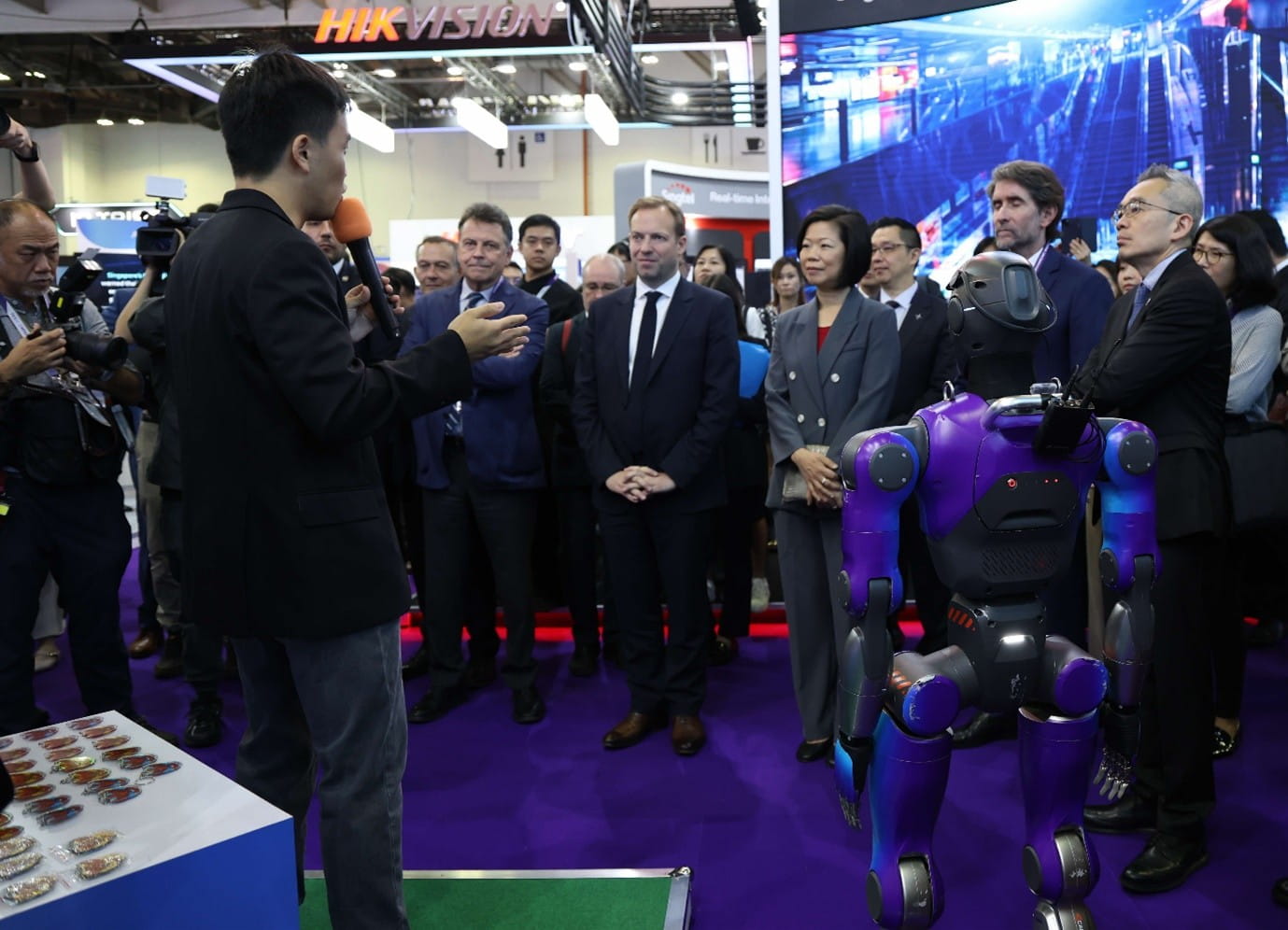 Tech demo where a presenter speaks to an audience about a humanoid robot.