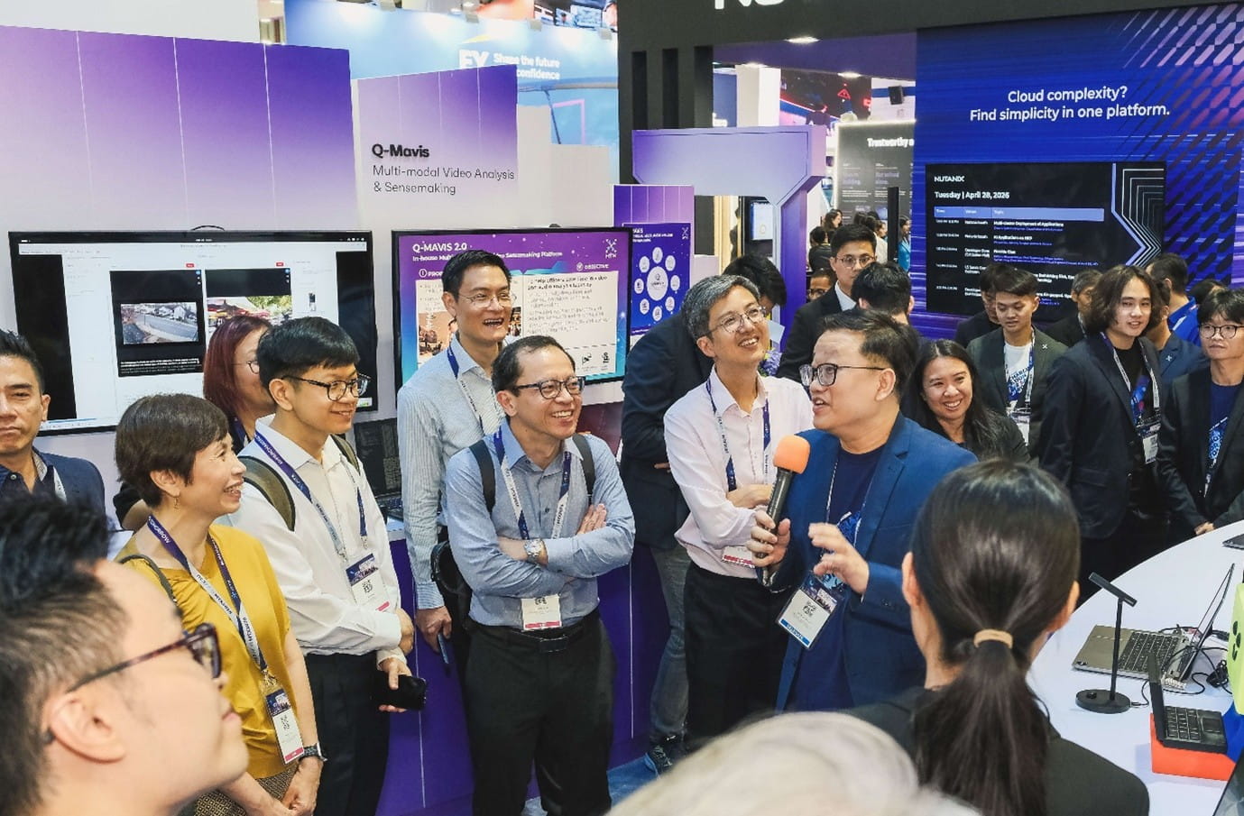 Tech booth where a presenter addresses a group of attendees.