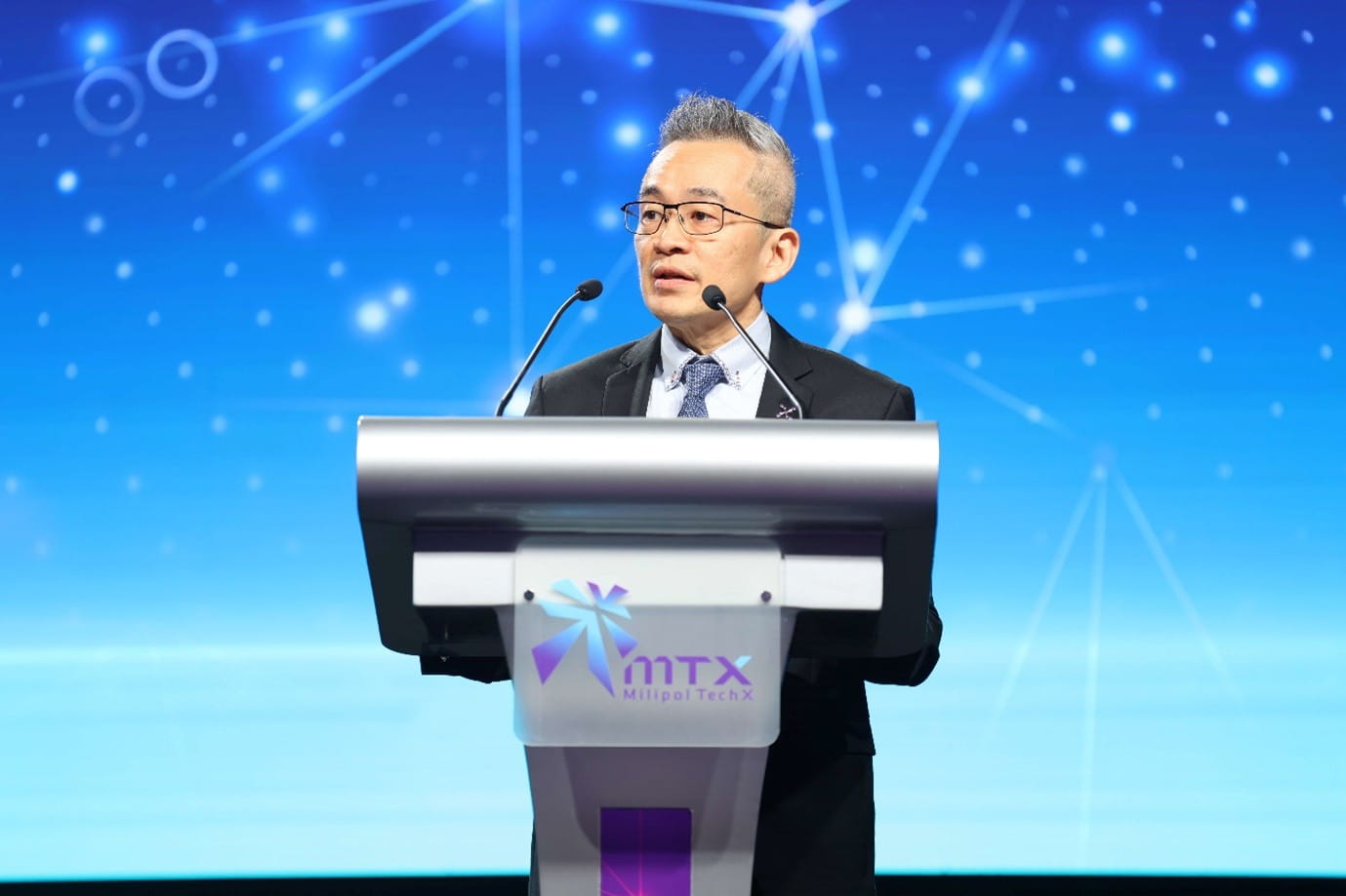 Man speaking at a podium with a microphone.