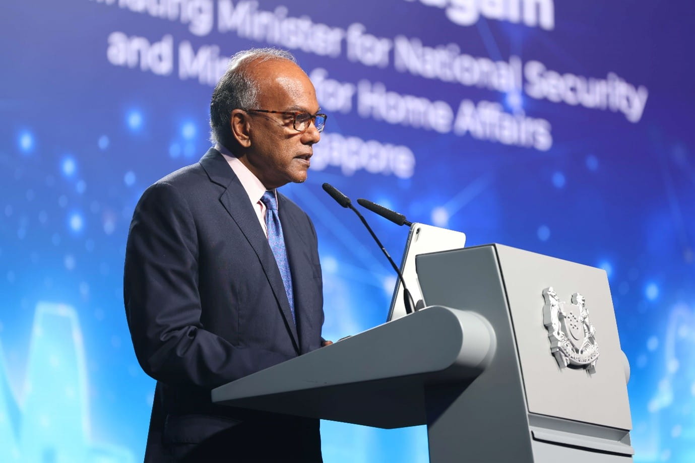 Man speaking at a podium with a microphone.