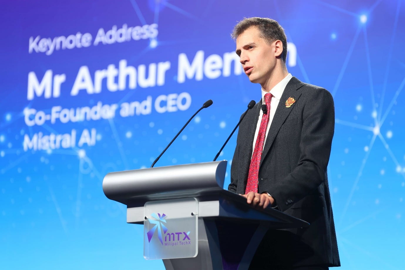 Man speaking at a podium with a microphone.