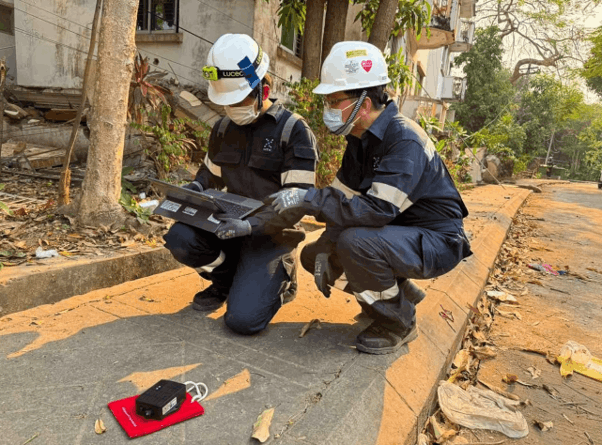 Pair of men squatting on road