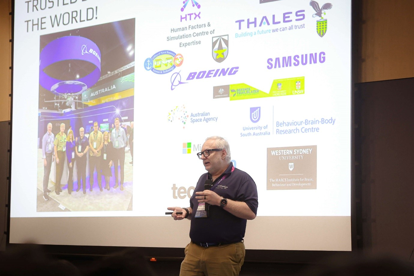 A man giving a presentation in front of a projection screen.