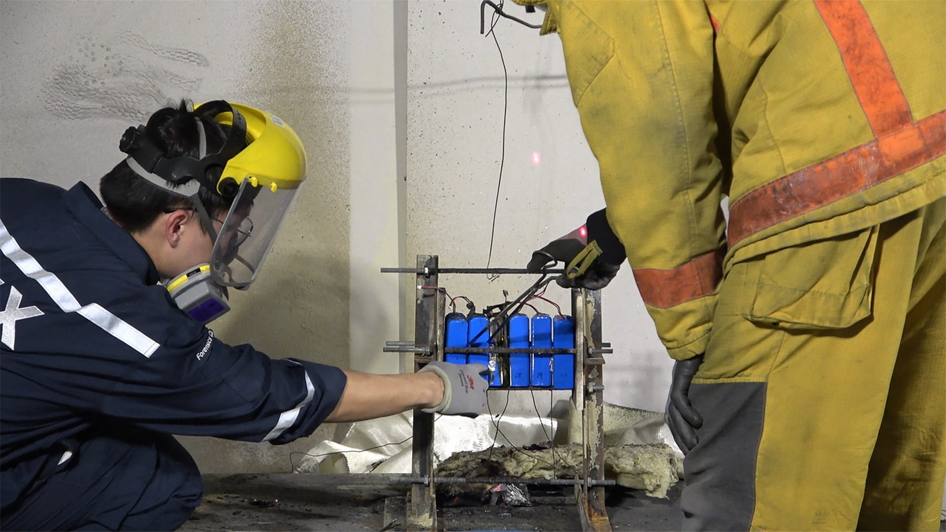 Investigators examining a battery pack.