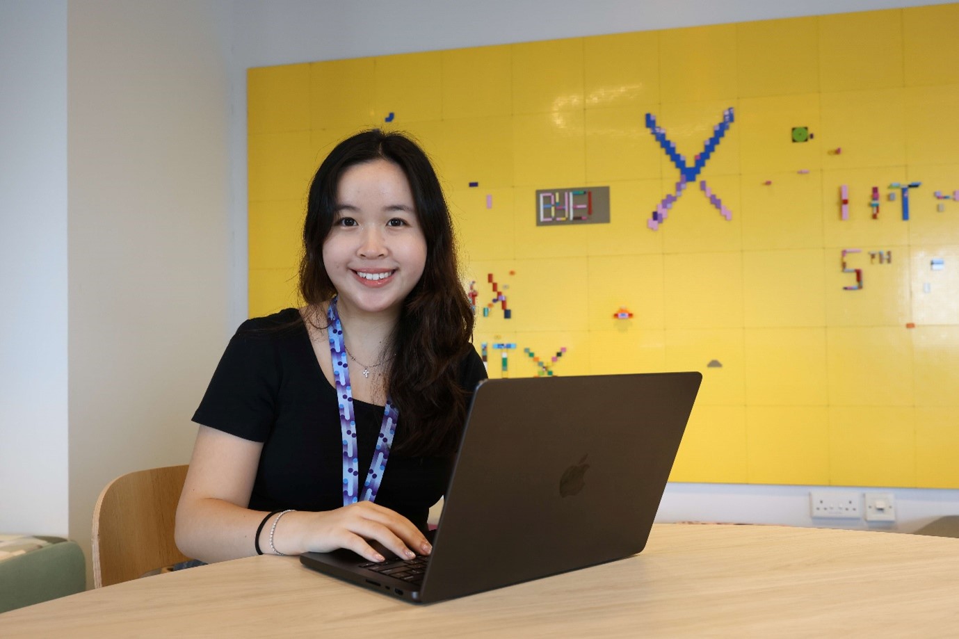 A young lady sitting at a table with a computer.