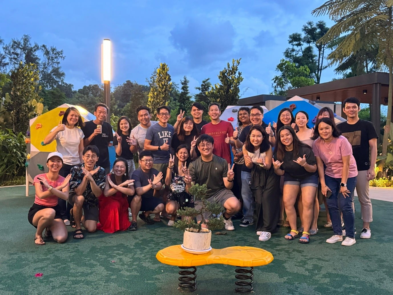 A group of people posing outdoors at a playground.