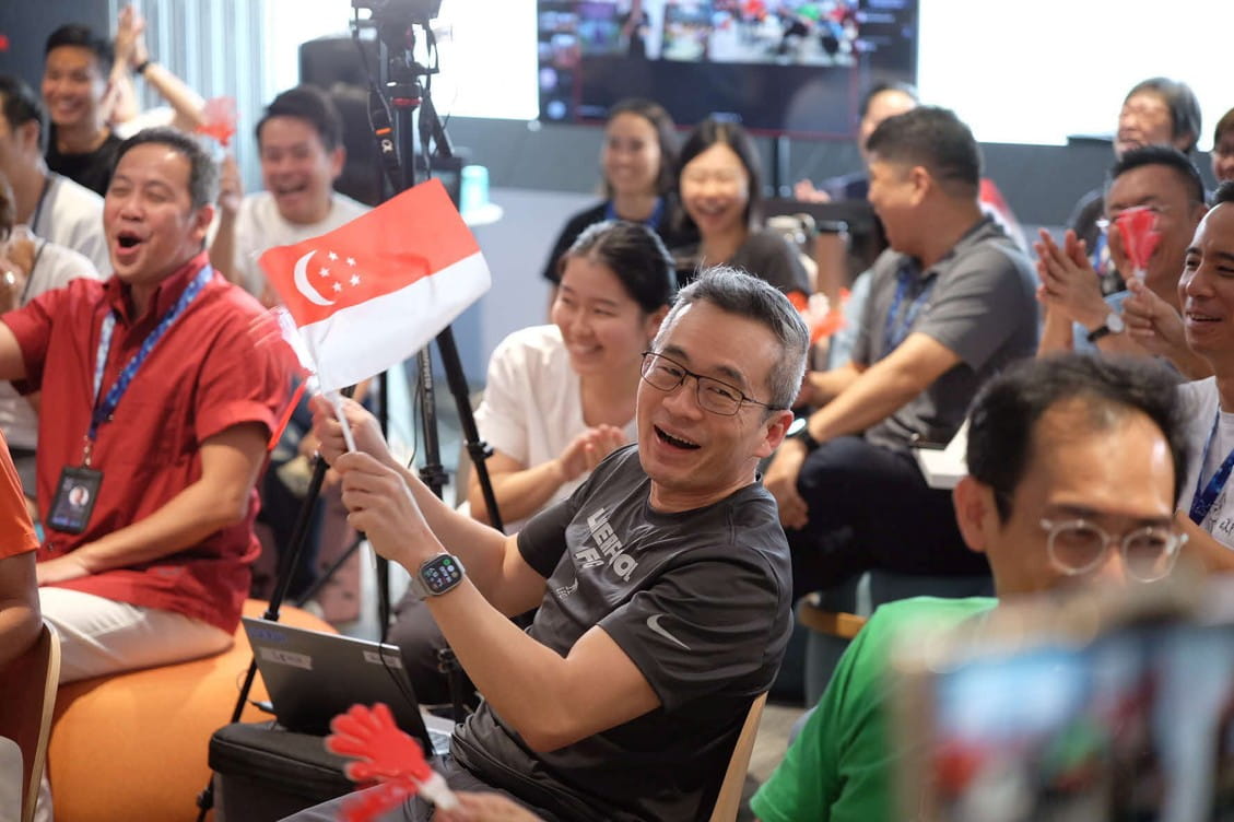 Man waving a handheld Singapore flag.