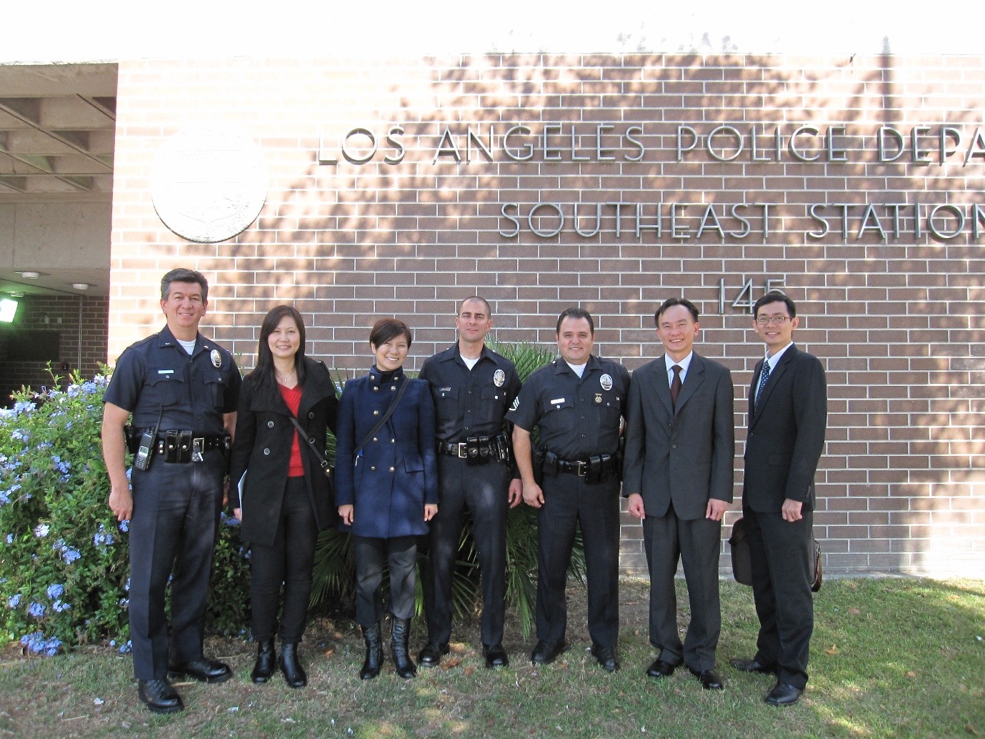 A group of people standing in front of a wall sign.