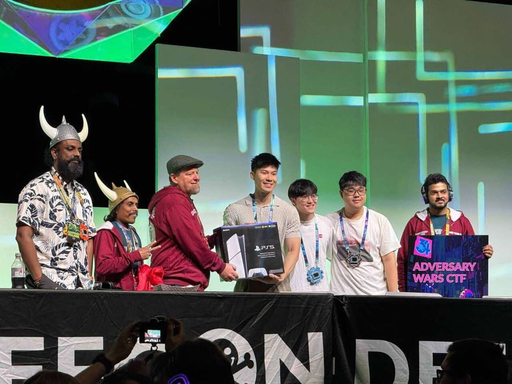 Group of seven people standing, smiling and posing for a celebratory photo.