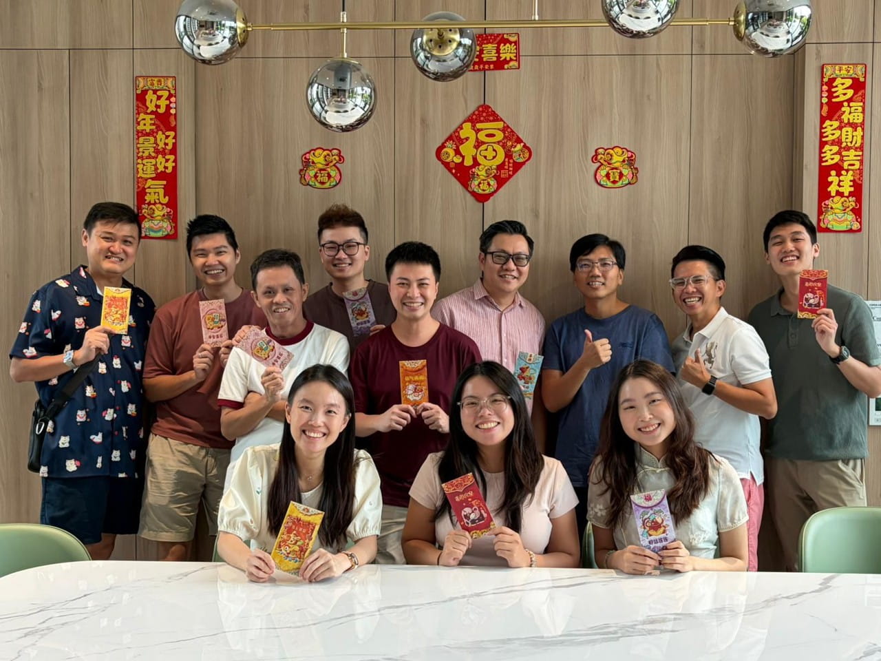 A group of male and female colleagues gathers around a white table.