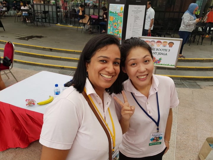 Two smiling women posing at an outdoor event.