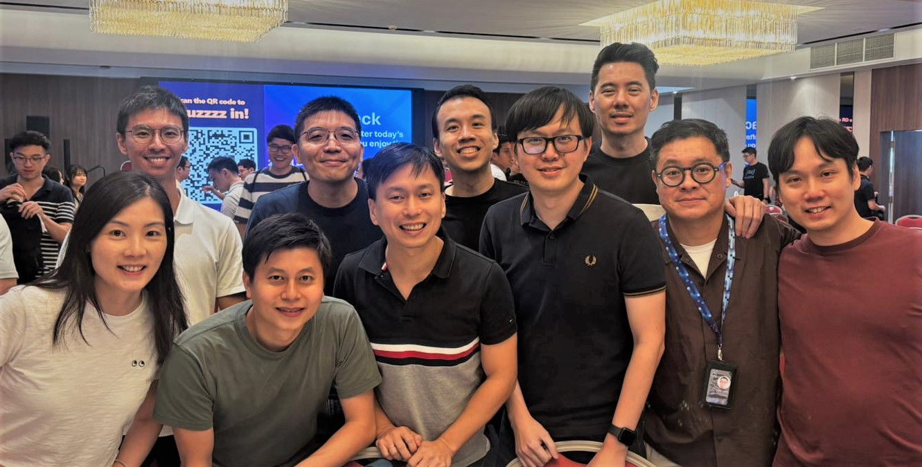 Group photo of people smiling indoors at an event.